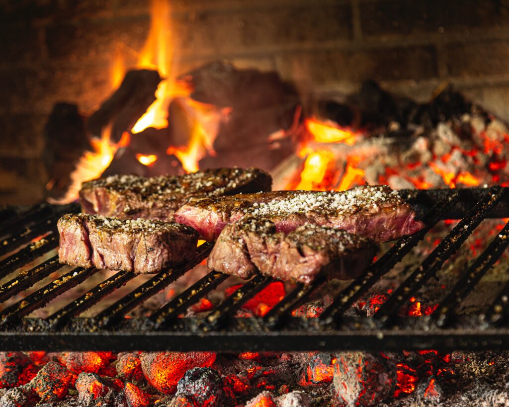 Steak cooking over hot coals