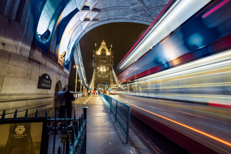 Nightime image of a bus crossing Tower Bridge in London