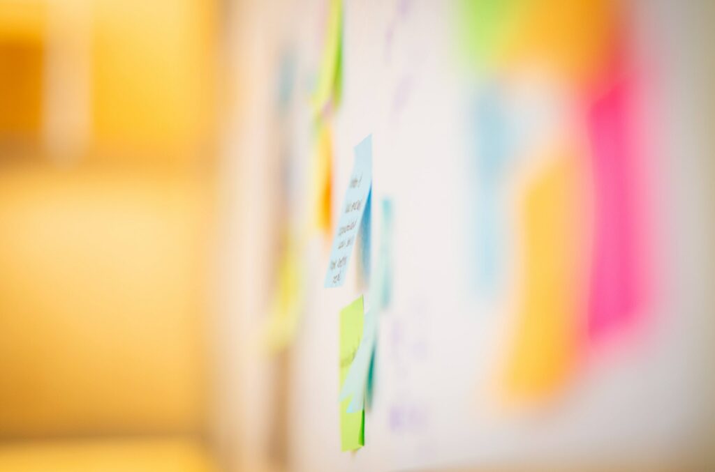 A blurred image of coloured post-it notes on a wall.