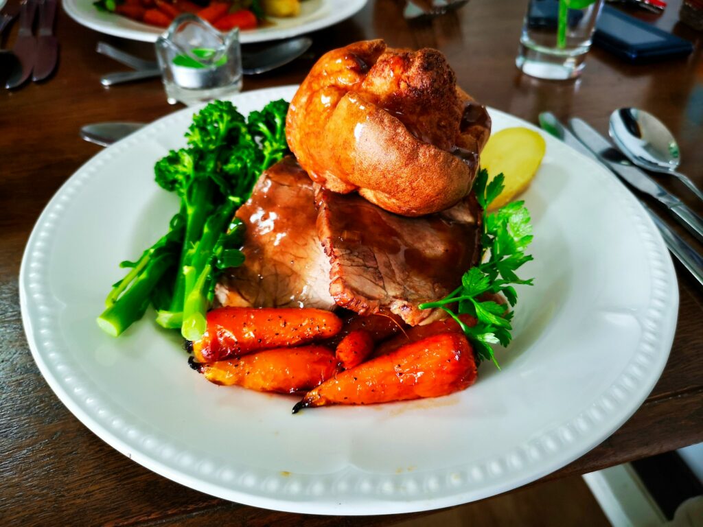 Roast beef dinner with carrots, broccoli and Yorkshire pudding.