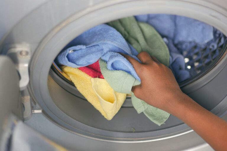 Hand pulling towels out of a washing machine